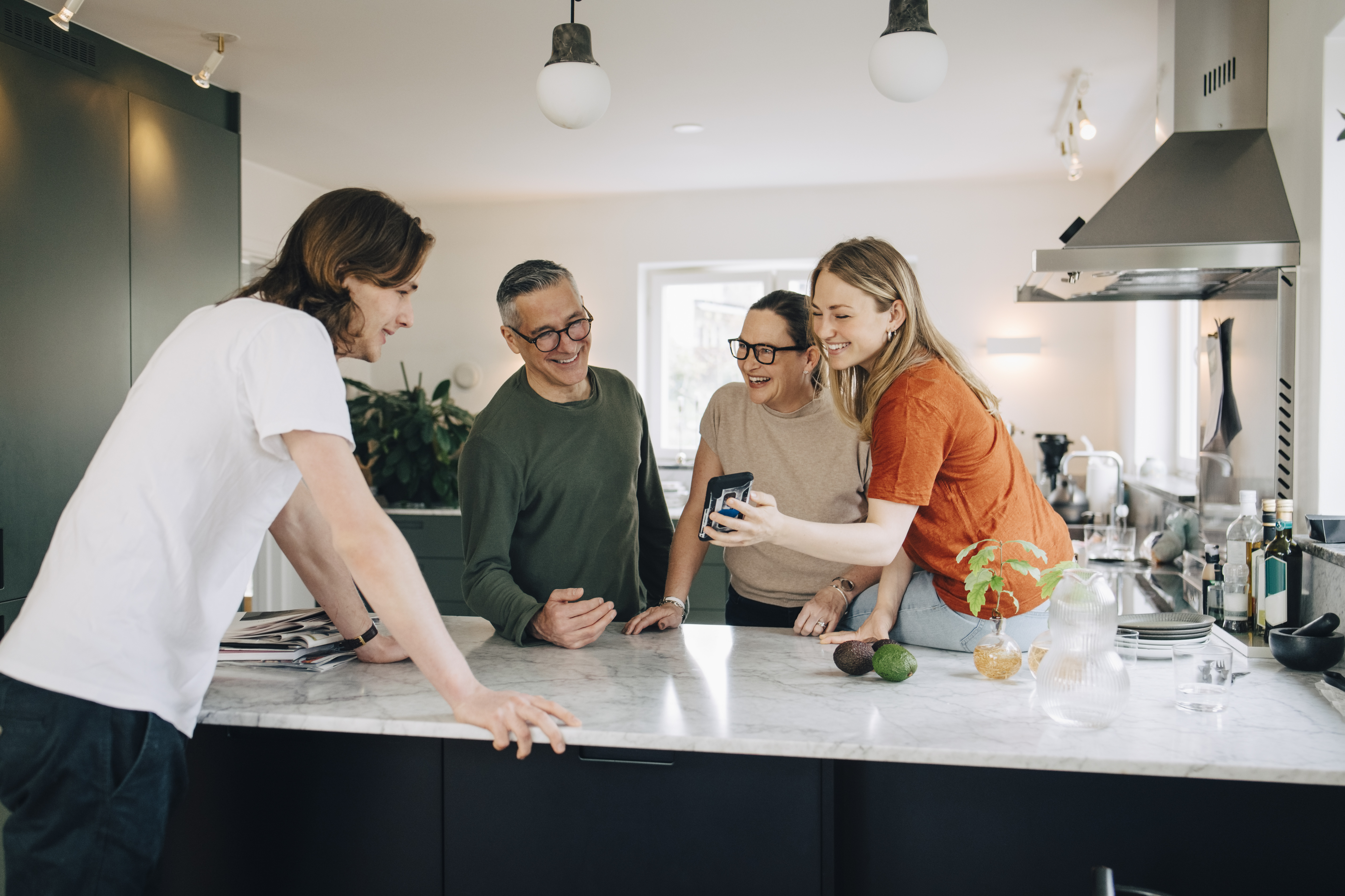 A family talking and laughing in the kitchen | Source: Getty Images