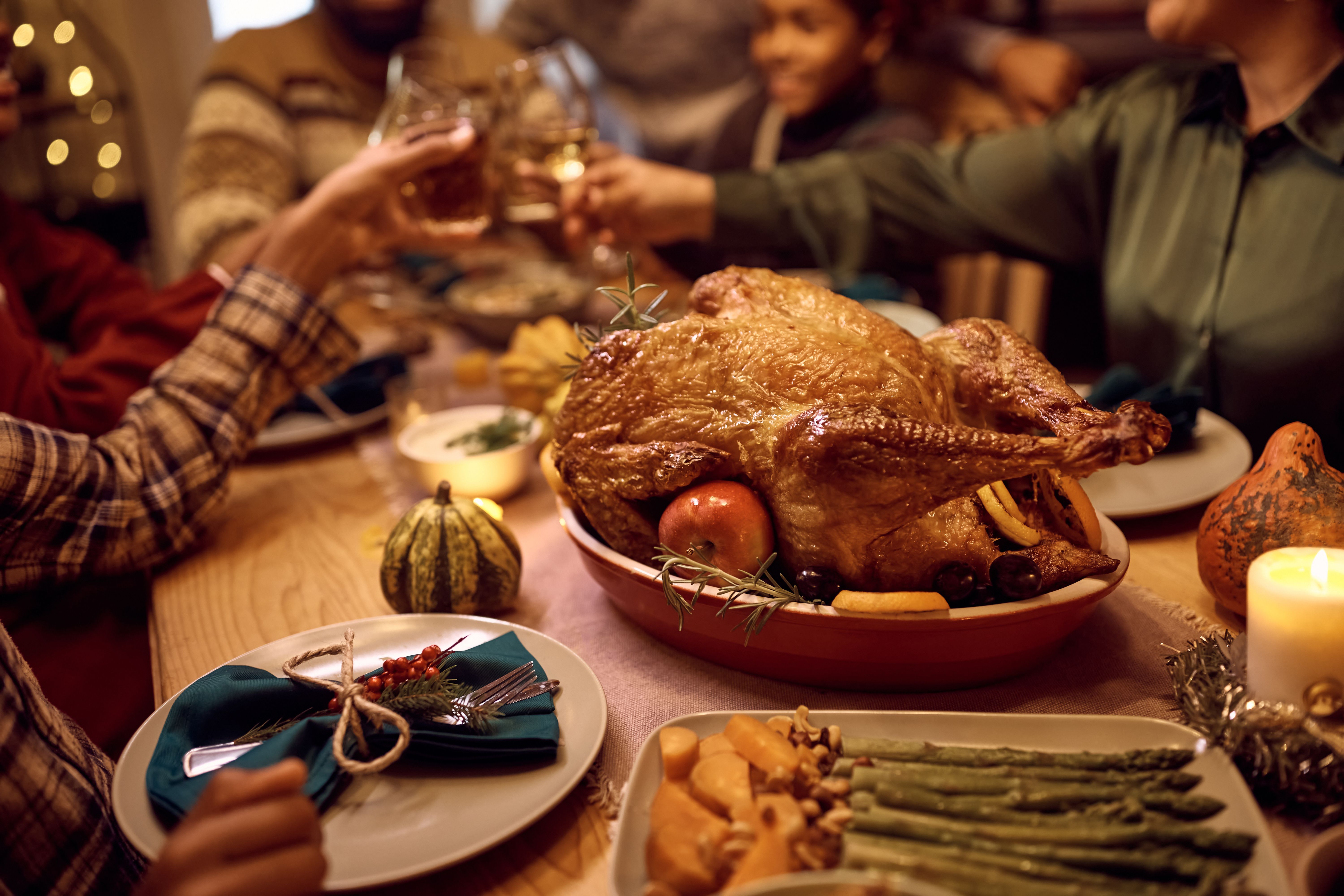 Roast turkey and people making a toast. | Source: Getty Images