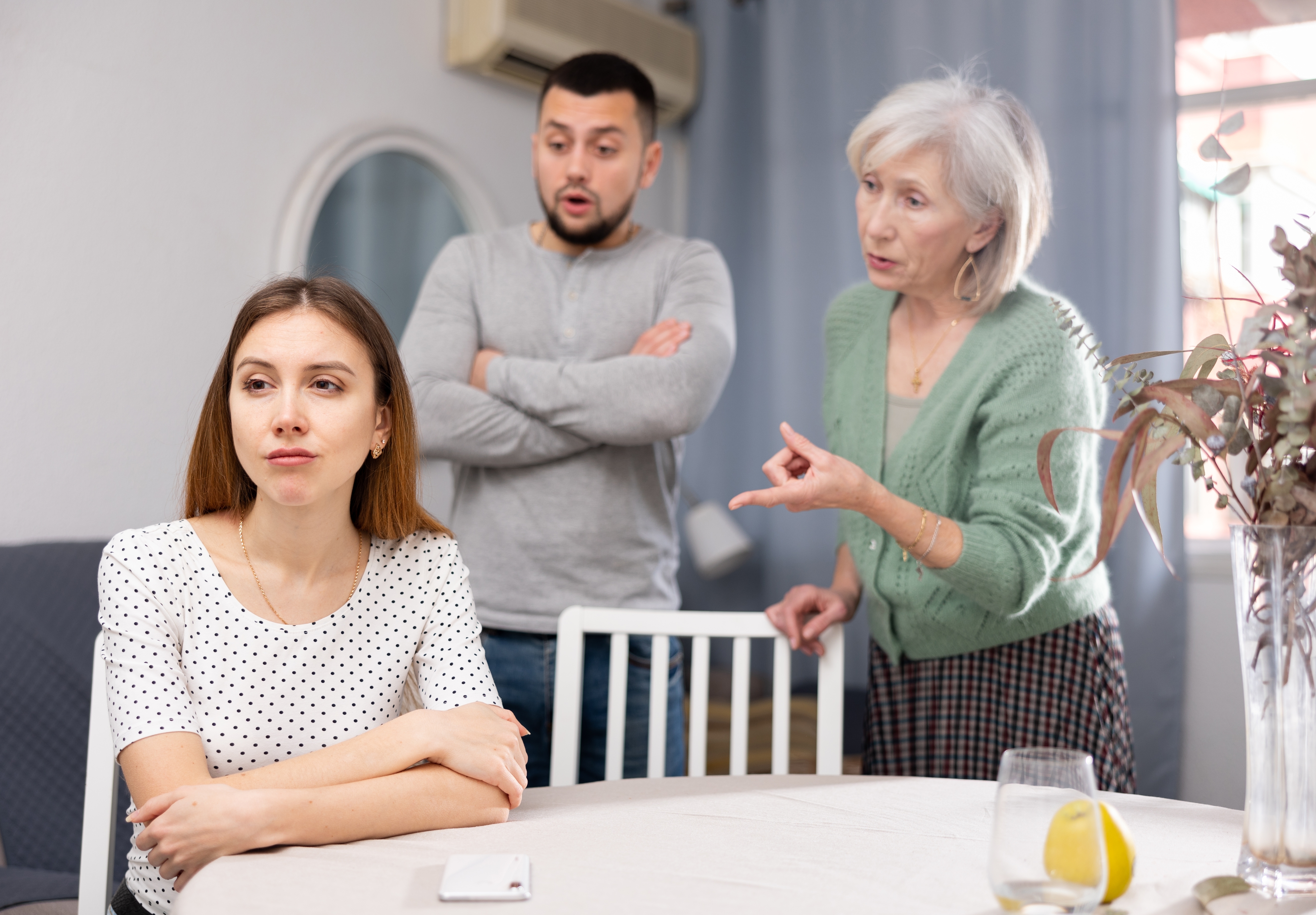 A woman crying as her husband and his mother talk to her | Source: Shutterstock