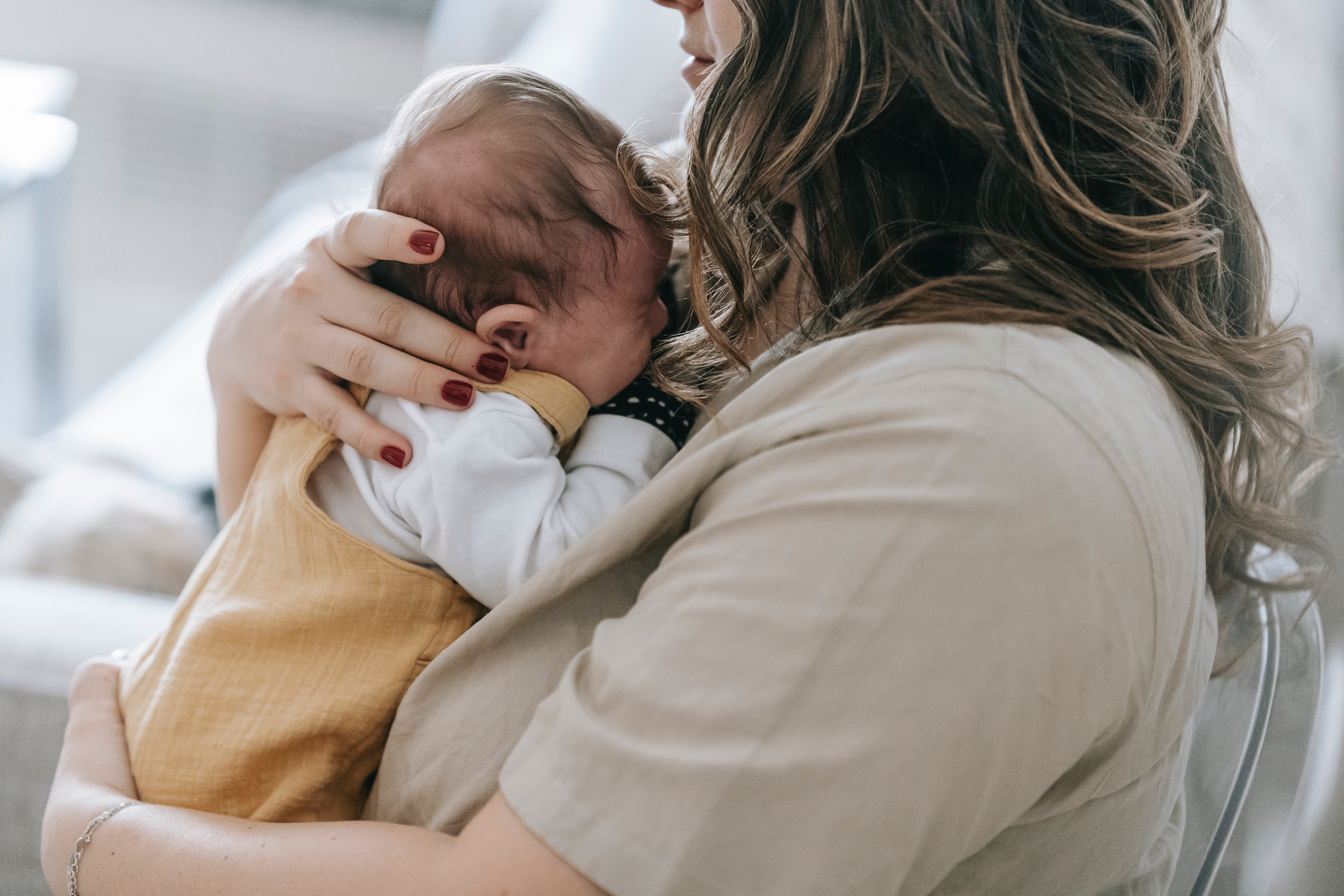 A woman holding her baby close. | Source: Pexels