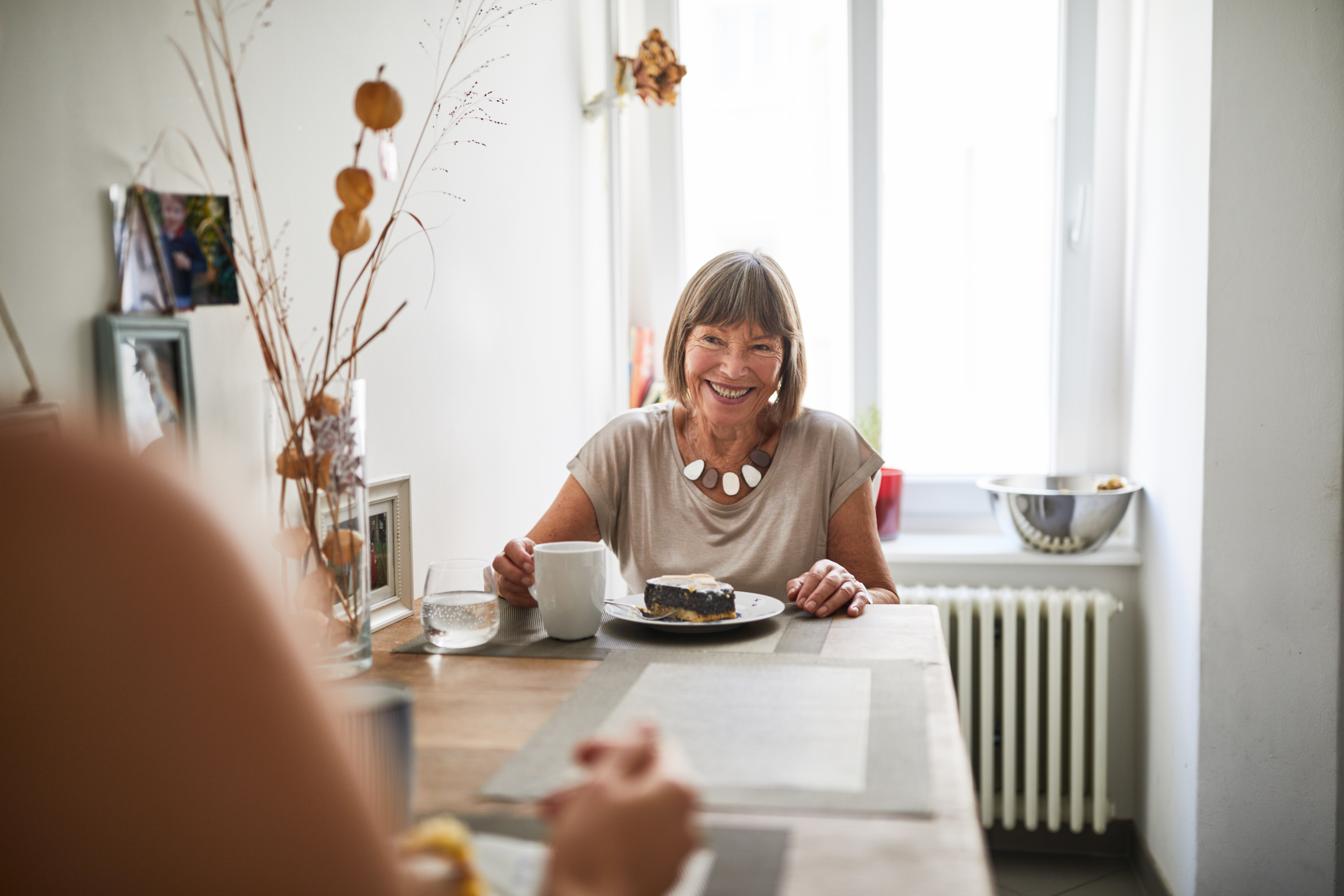 Mature woman laughing in the kitchen | Source: Getty Images