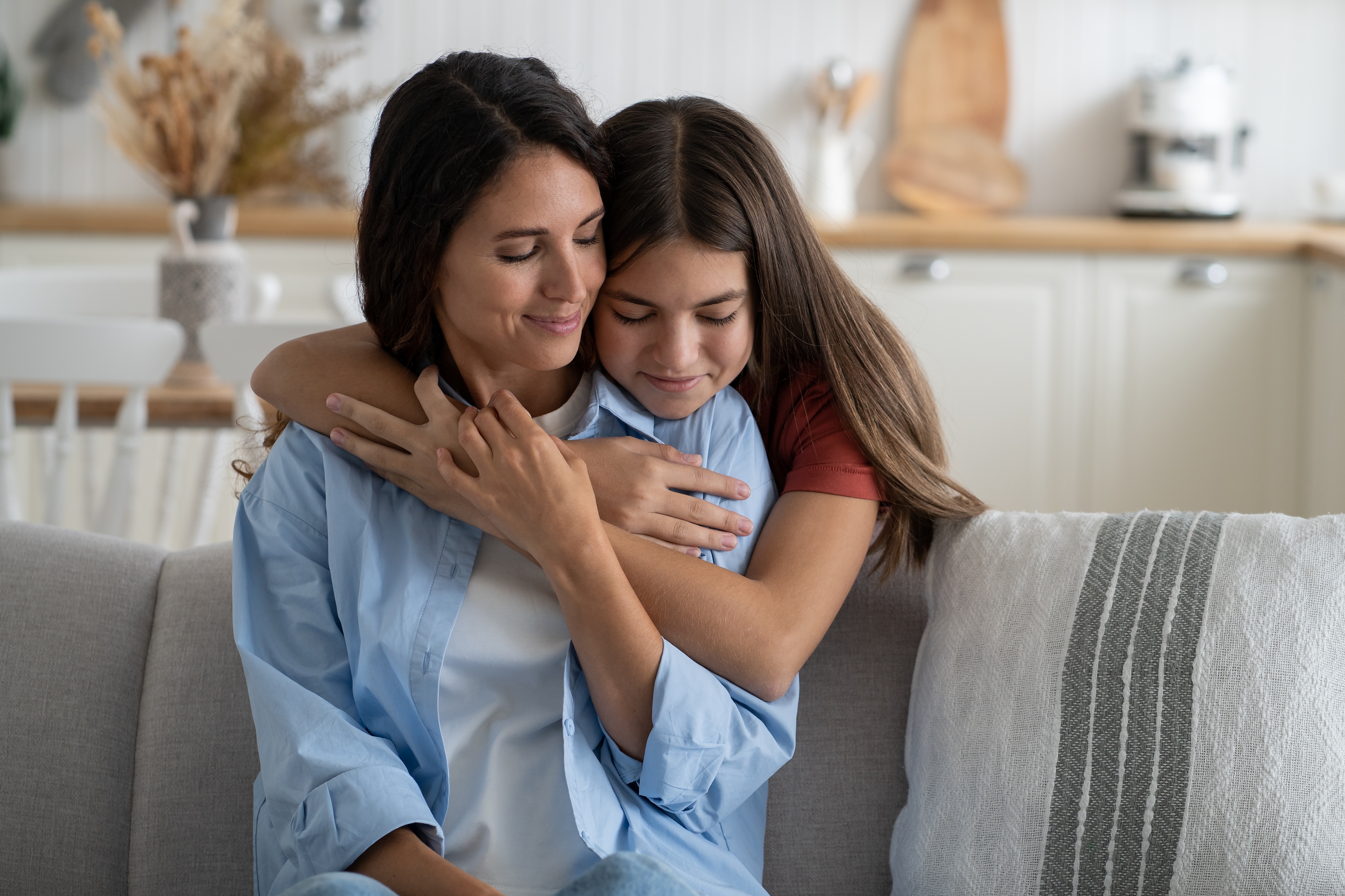 A young girl hugging her mother | Source: Shutterstock