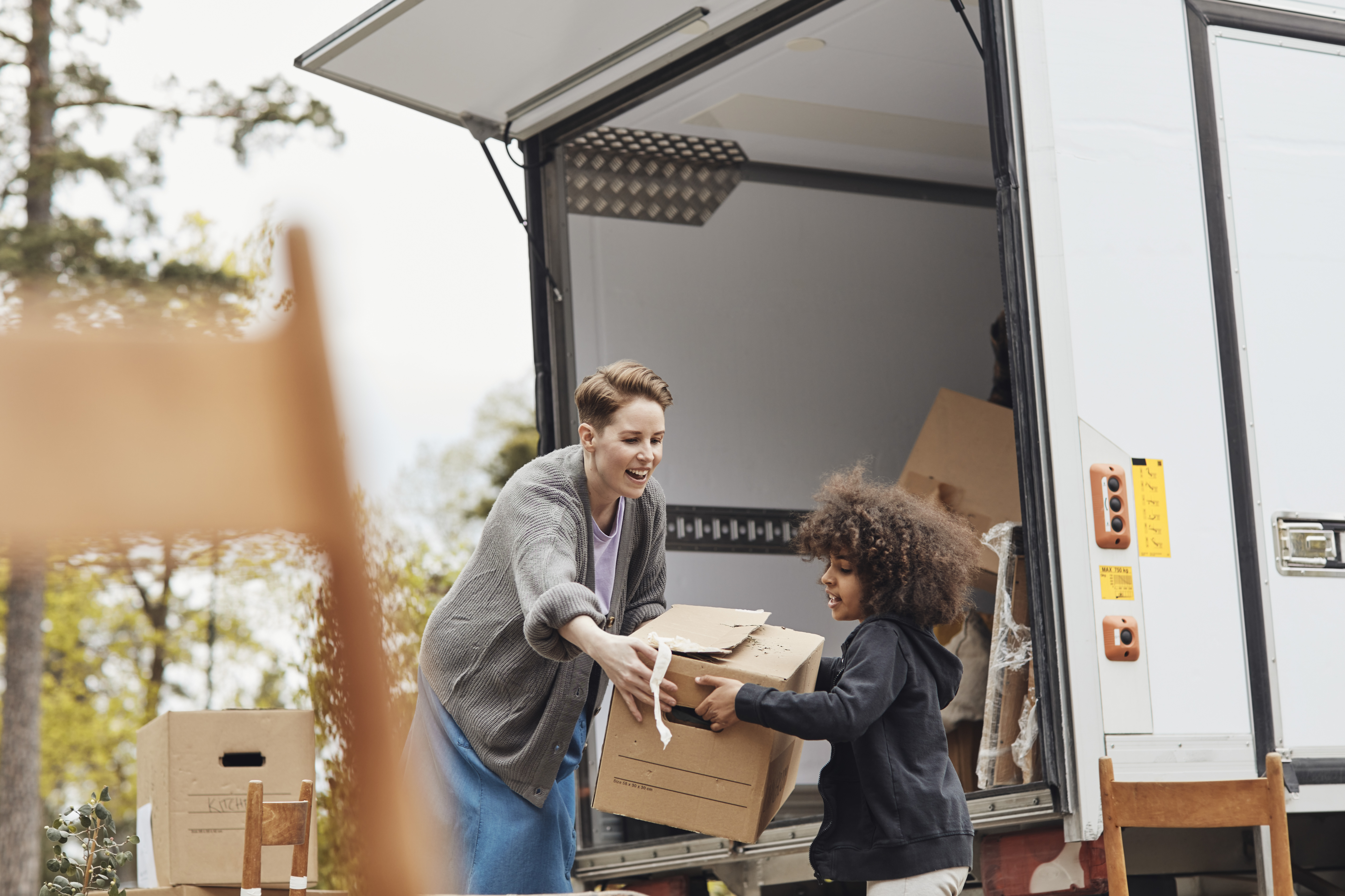 Woman handing a child a moving box | Source: Getty Images