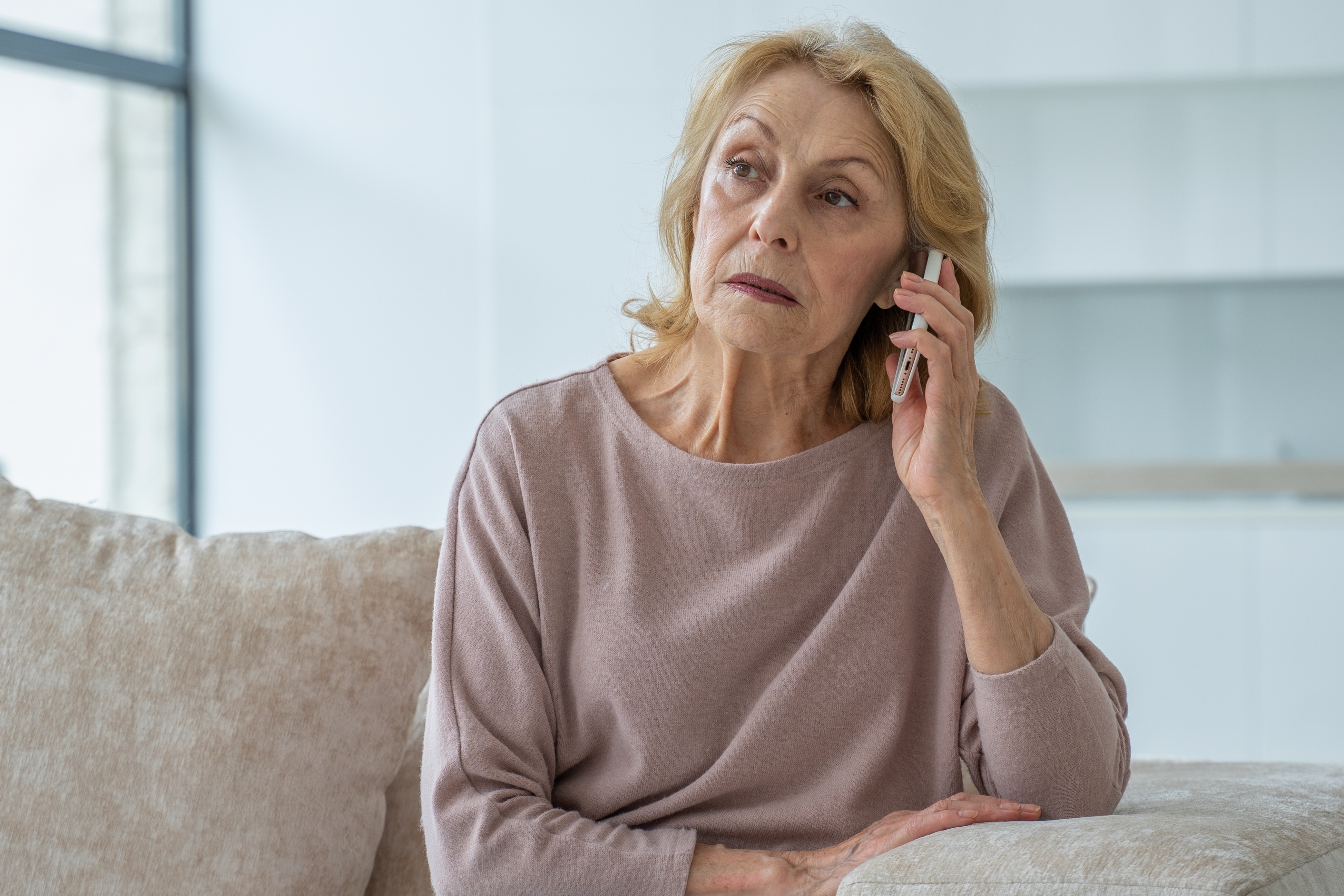 An older woman holding a cell | Source: Shutterstock