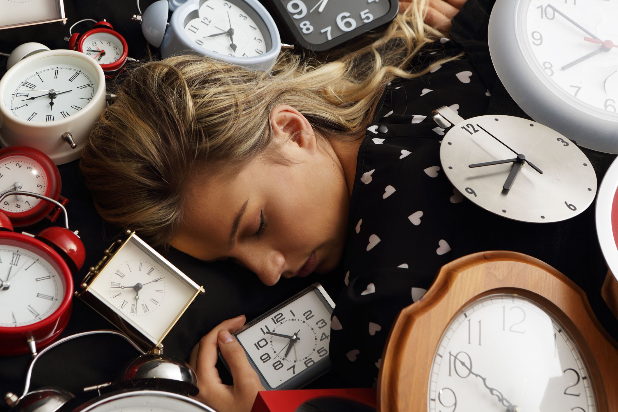 A woman sleeping with many clocks. | Source: Getty Images